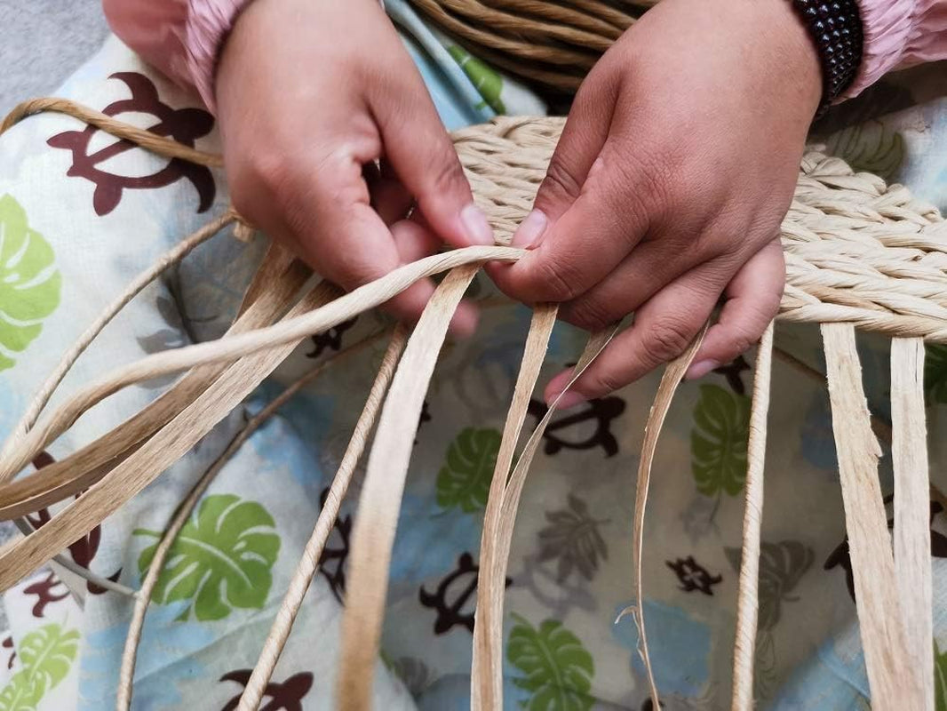 Close-up of hands working with woven material on a patterned fabric background