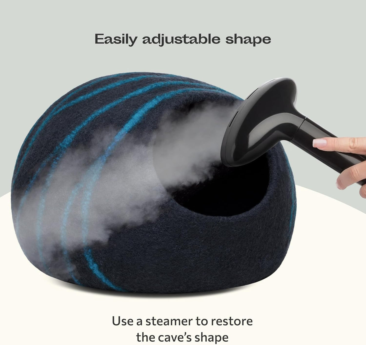Black and aquat marbled cat bed being steamed with a hand holding a steamer, on a light gray background.