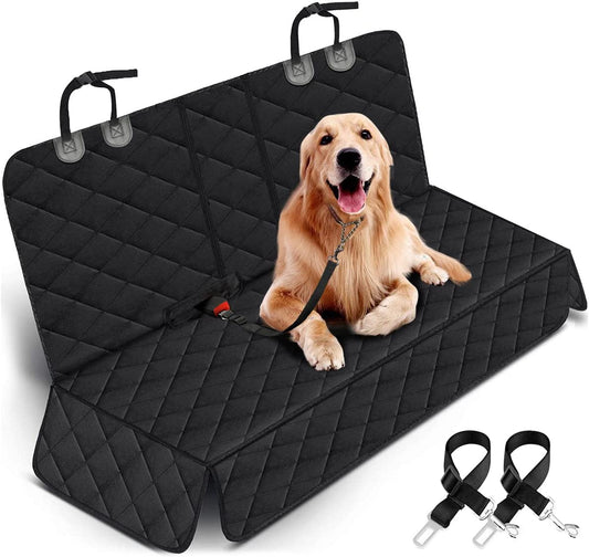 Dog sitting on a black car seat cover with straps on a white background